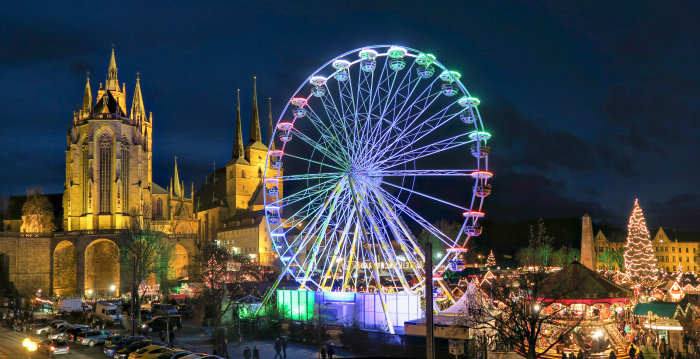 Illuminated big wheel at the market. In the background are the St. Mary's Cathedral and the Church of St. Severus
