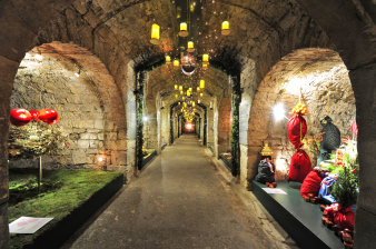 big yellow candles lighten the corridor of the vault, which is decorated with greenery, moss and christmas bags