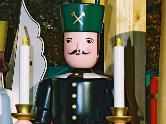 shaped, painted, wooden figure in miner´s uniform with two candles in the hand