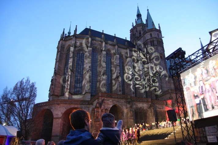 Mann mit Kind besichtigen Konzert vor illuminiertem Erfurter Dom