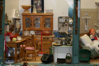 Foto: Puppenstube © Stadtverwaltung Erfurt / S. Glaubrecht Puppenküche und Puppenwohnzimmer mit Küchenbuffet, Tisch, Stuhl, Herd und Kruzifix über dem Chaiselongue.