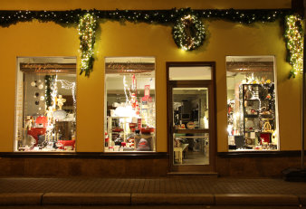 weihnachtlich geschmückte Häuserfront mit drei Schaufenstern und Eingangstür