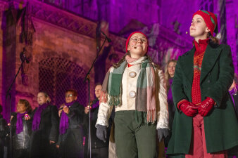 mehrere Menschen singen, im Fokus zwei als Wichtel verkleidete Personen
