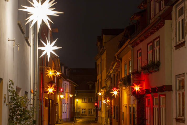eine mit leuchtenden Sternen weihnachtlich geschmückte Gasse in Erfurt