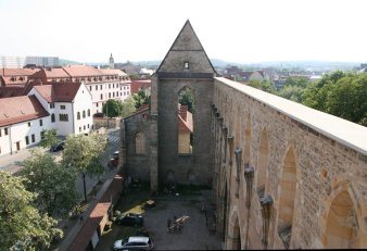 Foto: Blick auf die Ruine der Barfüßerkirche © Stadtverwaltung Erfurt Blick auf die erhaltene Giebelseite der Kirche, die Wand die Hauptschiffes rechts im Bild. Dahinter die Stadt, unten, im ehemaligen Kirchenraum, Autos.