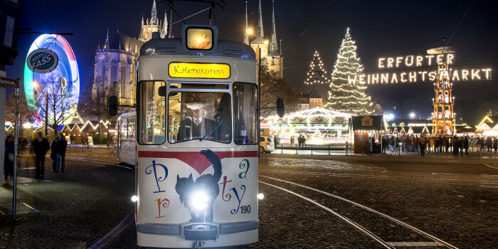 Ältere Straßenbahn mit schwarzem Kater vom Weihnachtsmarkt kommend