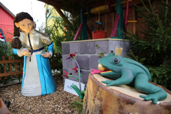 Princess watches the frog king holding a golden ball in its mouth