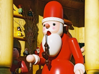 shaped, painted, wooden figure with red, white coat, beard and pipe