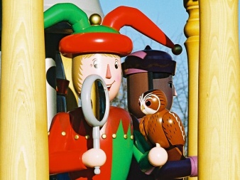 shaped, painted wooden figure with fool´s cap, mirror and owl in the hand