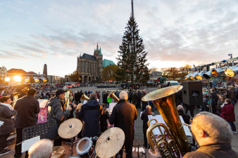 Blasorchester vor Domplatz, im Hintergrund der Tannenbaum und die Dom-Silhouette