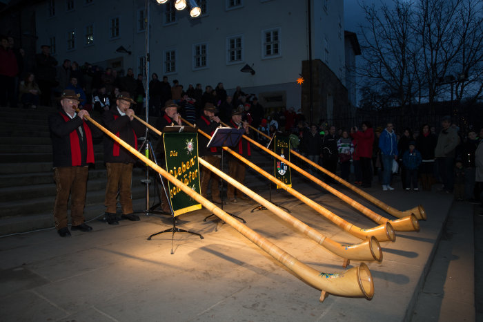 Fünf Alphornbläser mit ihren langen aus Holz bestehenden Instrumenten